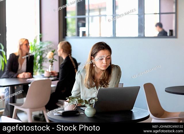 Businesswoman in cafe using laptop