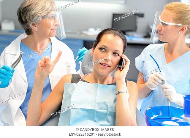 Busy businesswoman at dental surgery on phone