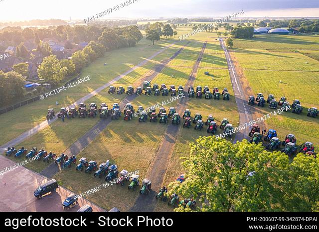 07 June 2020, Lower Saxony, Hude: In the evening, farmers sit in their tractors on a large meadow and watch the documentary ""Die schöne Krista"" about a cow...