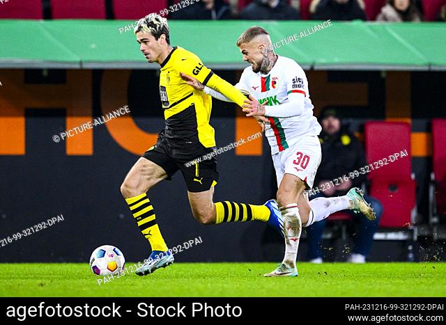 16 December 2023, Bavaria, Augsburg: Soccer: Bundesliga, FC Augsburg - Borussia Dortmund, Matchday 15, WWK-Arena. Dortmund's Gio Reyna (l) in action against...