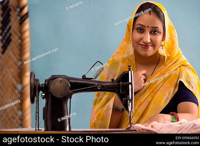 A woman smiling with a sewing machine