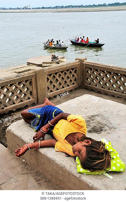 Young girl sleeping deeply at the ghat by the Ganges river