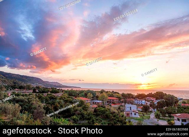 Sunset over Calabria coast with village next to the Tropea town in Vibo Valentia, Calabria, Southern Italy