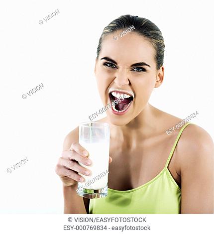 beautiful brunette caucasian woman on white background holding a glass of milk