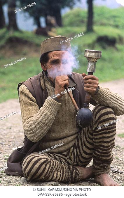 a garhwali man smocking hookah , garhwal , uttaranchal , india
