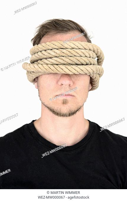 Man with covering eyes and ears, rope