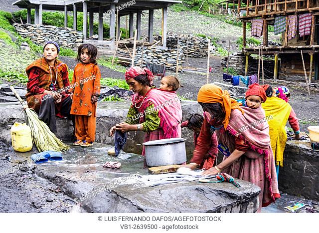 Women with children doing laundry. Malana village, Himachal Pradesh, India
