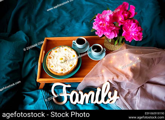 Beautiful morning Vanilla cheesecake, coffee, blue cups, pink peonies in a glass vase. View from above