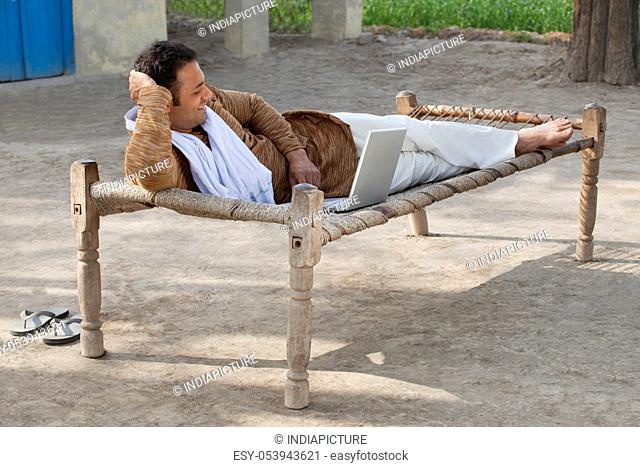 Relaxed rural man using laptop