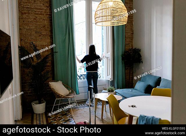Woman looking at view from window at apartment