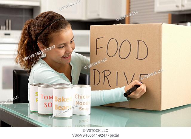 USA, Illinois, Metamora, Smiling girl (10-11) preparing food drive in kitchen
