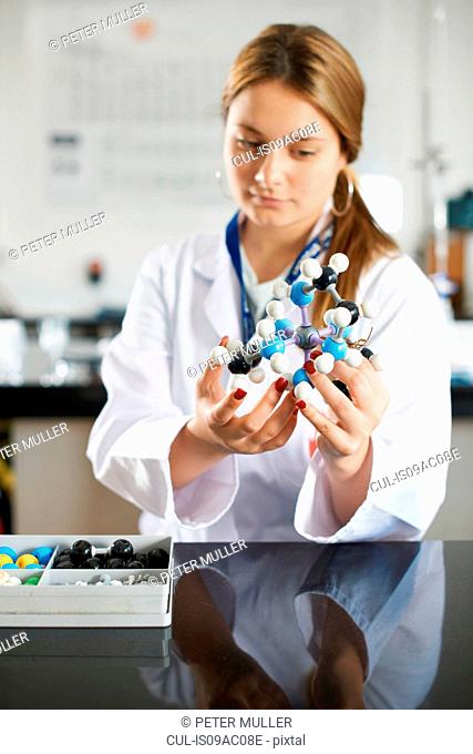 Teenage girl holding molecular model