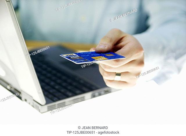 Man's hand with credit card and laptop