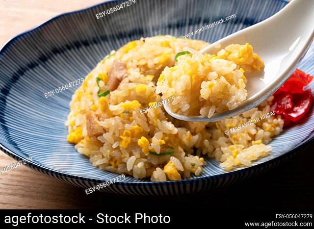 Scoop the fried rice with a Chinese soup spoon