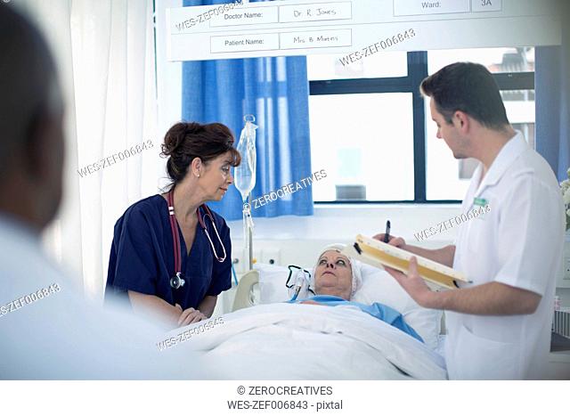Dpctor and nurse with patient in hospital bed