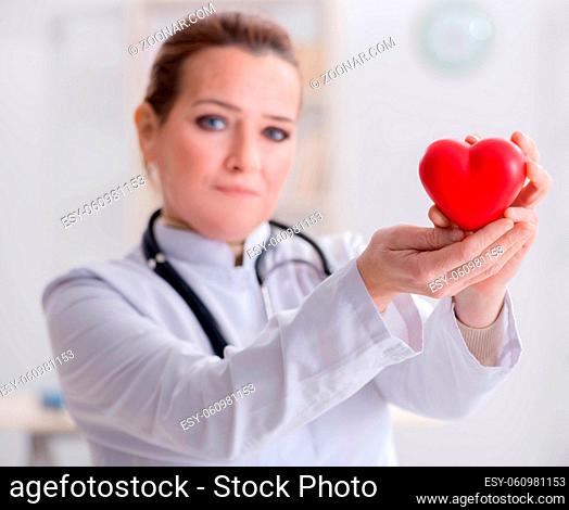 The cardiologist with red heart in medical concept