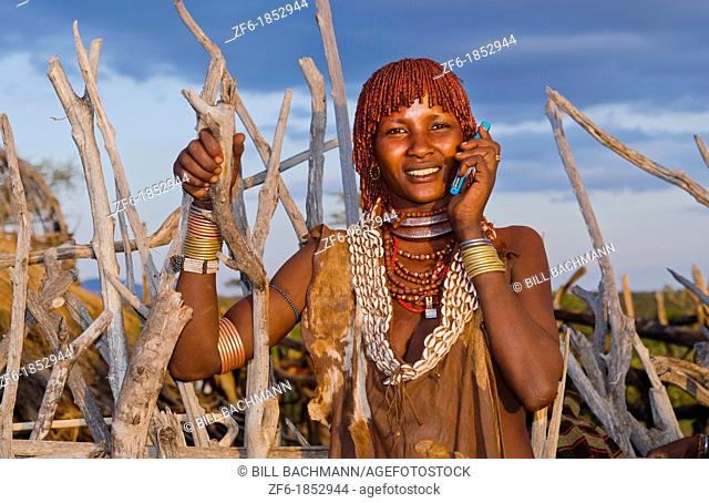Turmi Ethiopia Africa Lower Omo Valley village with Bena tribe First Wife smiling with jewelry in wild wood camp hut 24