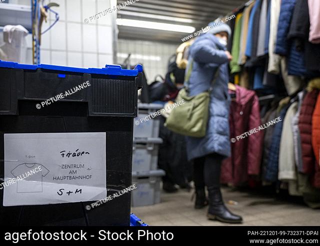 PRODUCTION - 28 November 2022, Berlin: A plastic box with women's shirts stands on the floor in the clothing store of the Berliner Stadtmission