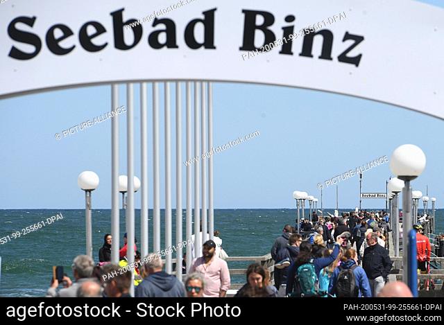 31 May 2020, Mecklenburg-Western Pomerania, Binz: Tourists walk over the pier. Lively north-easterly wind has brought joy to surfers and kite surfers