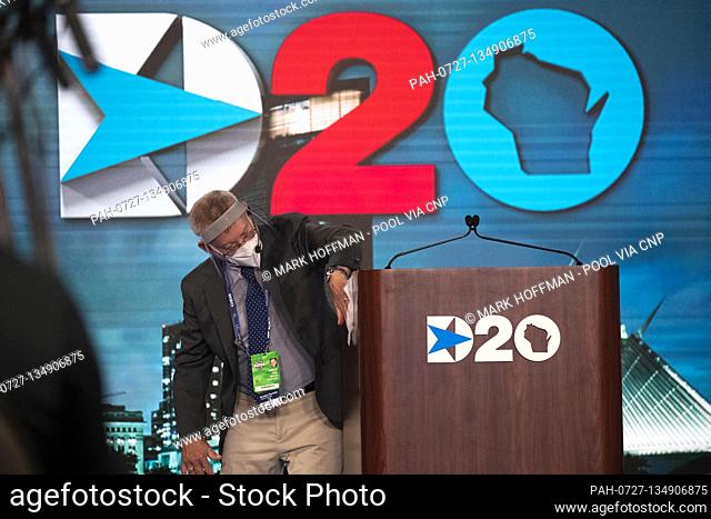August 20, 2020; Milwaukee, WI, USA; Douglas Fogel cleans the podium after Democratic National Committee Chairman Tom Perez spoke during the Democratic National...