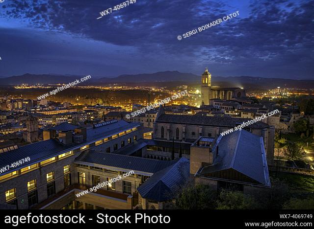 The city of Girona seen from the Sant Domènec tower in the wall of Girona, at twilight and night (Girona, Catalonia, Spain)