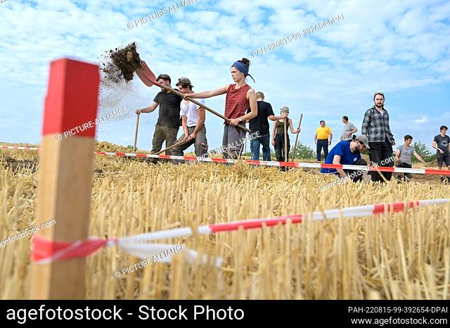 15 August 2022, Saxony-Anhalt, Helfta: Students working on the excavation area on a hill near Helfta. Extensive archaeological excavations continue on an area...