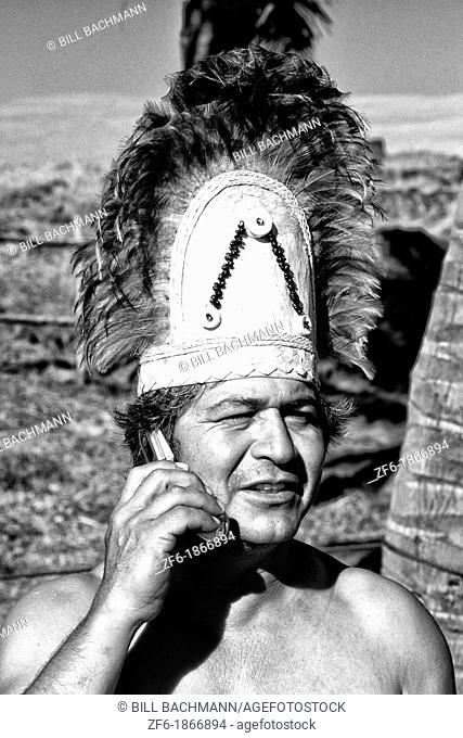 Local native and costume talking on cell phone Easter Island during Tapati Festival Rapa Nui