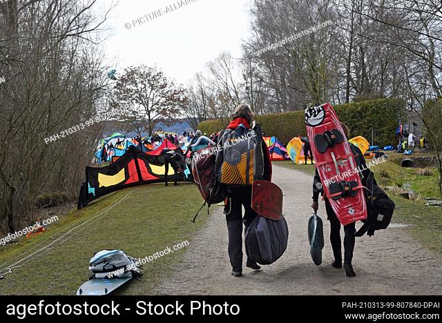 13 March 2021, Bavaria, Hersching: Two athletes go kitesurfing on the Ammersee with their equipment. Photo: Ursula Düren/dpa