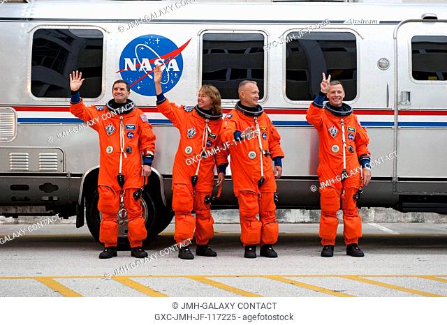 After suiting up, the STS-135 crew members pause alongside the Astrovan to wave farewell to onlookers before heading for launch pad 39A for the launch of space...