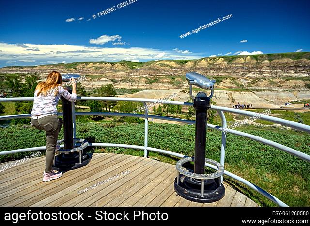 Tourists observing the landscape of the Canadian Badlands via binocular in Drumheller, the dinosaur capital of the world, Alberta, Canada