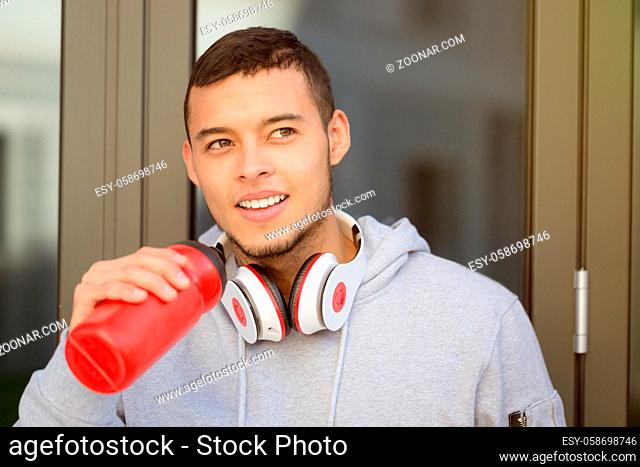 Smiling young latin man drinking water sports training fitness copyspace copy space outdoor