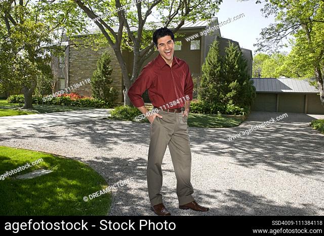 Hispanic man standing in driveway of home