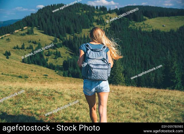 Rear View of a Sportive Girl Walking in the Mountains. Traveling along Amazing Fresh Mountainous Nature. Active Sportive Life. Carpathian. Ukraine