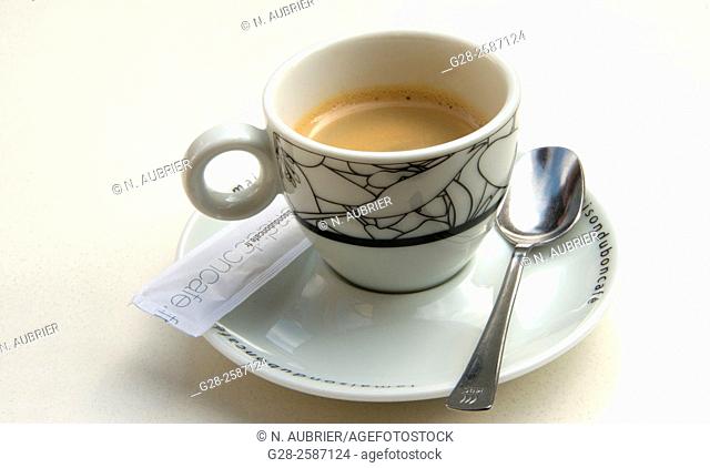 China cup full of coffee on a cafe table, with castor sugar and teaspoon, symbol of coffee break or danger of diabetes