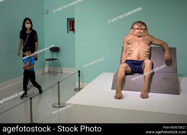 People look at Graham a sculpture of deformed man by Patricia Piccinini during the SUPERNATURAL: Sculptural Visions of the Body exhibition in Taipei