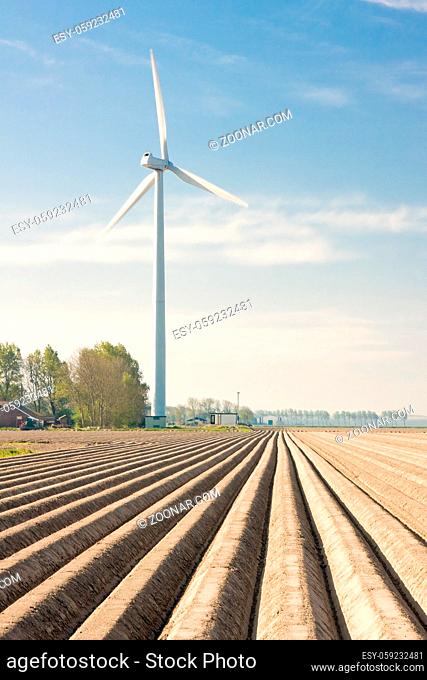 Bare farmland with a big windturbine