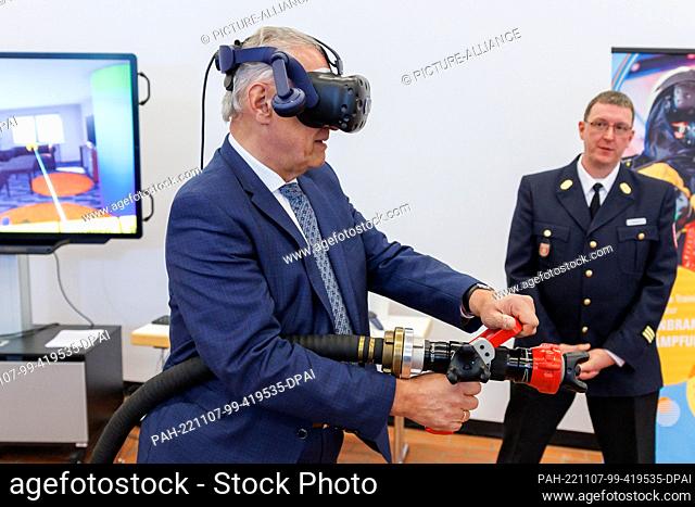 07 November 2022, Bavaria, Würzburg: Joachim Herrmann (l, CSU), Bavaria's Minister of the Interior, tries out virtual training for indoor firefighting at the...