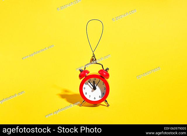Red retro alarm clock on yellow background. Minimal time concept. Christmas or New year eve. . High quality photo