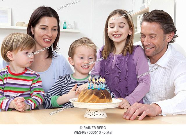 Germany, Bavaria, Munich, Family with birthday cake, smiling