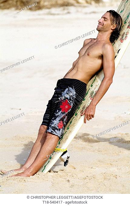 young man leaning to surfboard