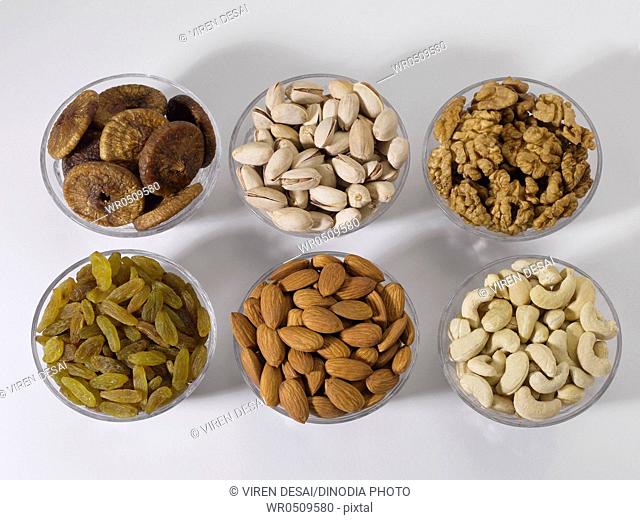 Dry fruits and nuts , almonds pistachios walnuts raisins figs cashew nuts in bowls