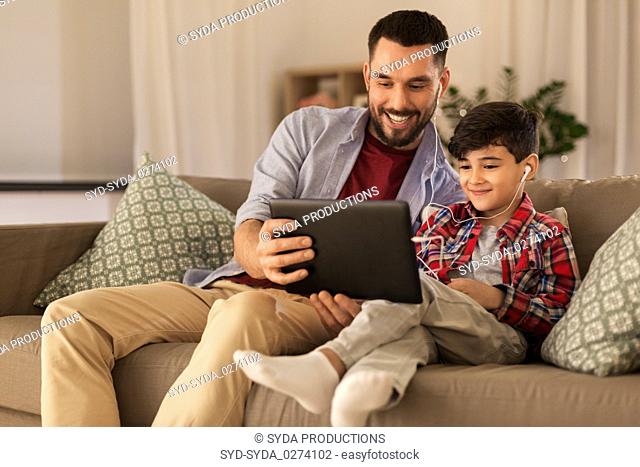father and son listening to music on tablet pc