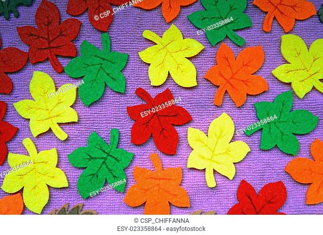 Yellow, red, orange and green Maple leaves out of felt on fabric