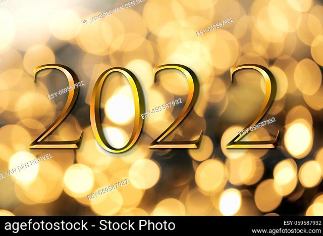 The year 2022 written on wooden cubes in gold luxury letters with shiny bokeh background, New Year celebration concept glitter beauty