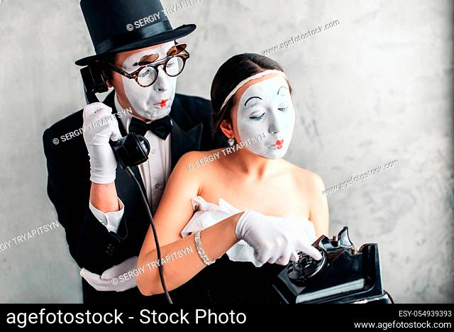 Pantomime theater actor and actress performing. Mime artists with white makeup masks on faces