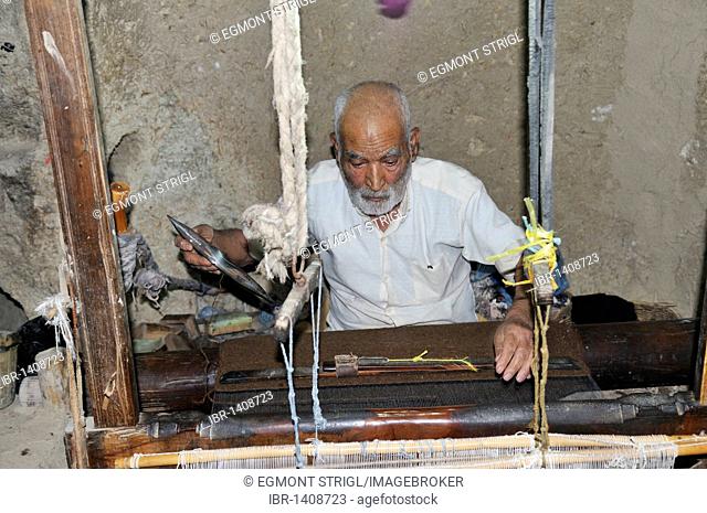 Old Iranian man weaving in his underground shop, Nain, Isfahan, Esfahan, Iran, Persia, Asia