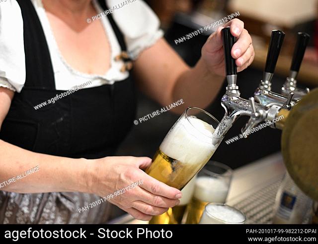 17 October 2020, Bavaria, Garmisch-Partenkirchen: A waitress taps beer in an inn. Almost half of the Bavarian districts and independent towns are now subject to...