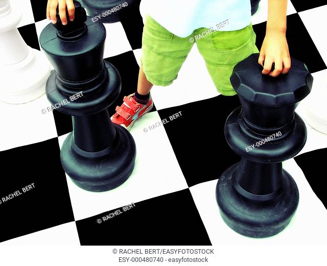 Boy playing on life-size chess board