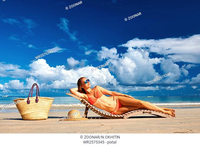 Woman in bikini lying on beach at Seychelles