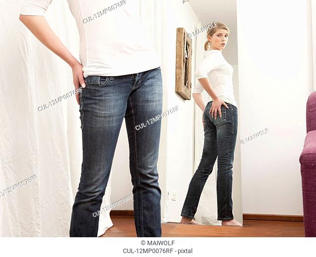 Woman checking her body in the mirror